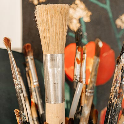 A group of paint brushes in a basket for art therapy for adults