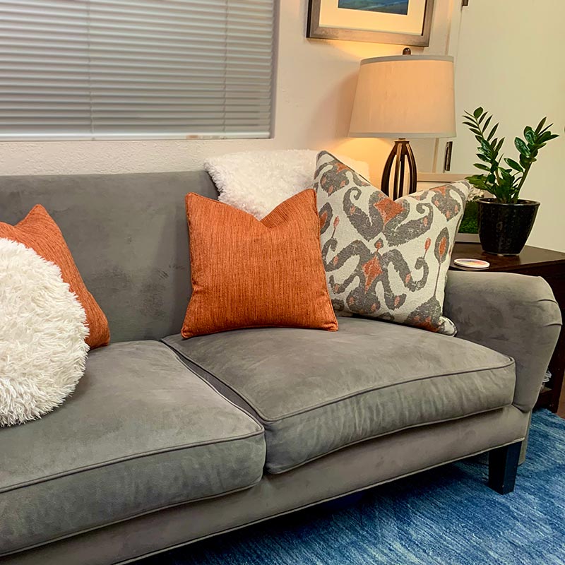 A gray couch with orange pillows in a Calabasas therapist office